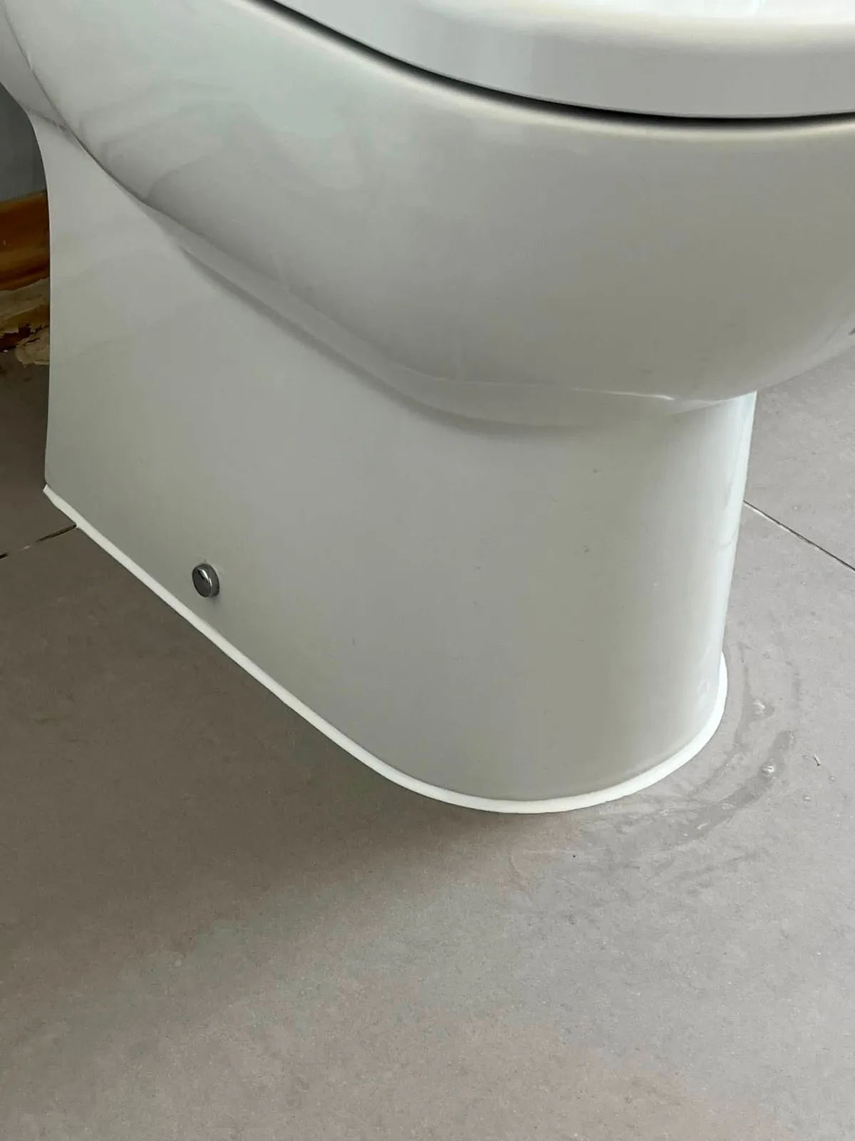 Clean white silicone seal around the base of a toilet
